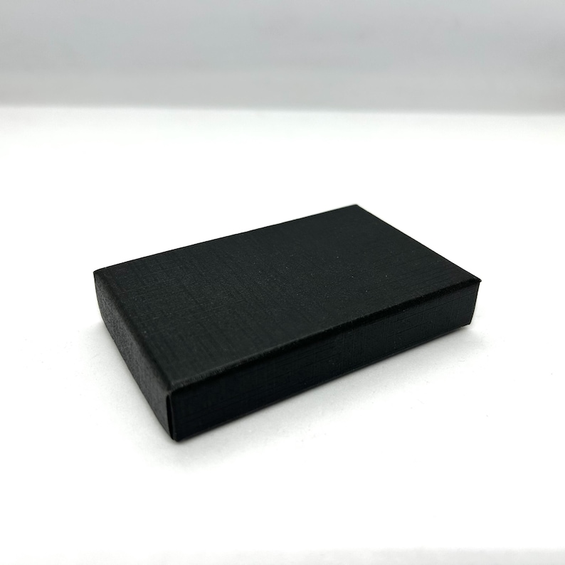 May include: A black rectangular box with a textured surface.
