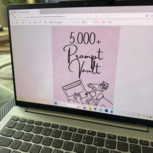 Puede incluir: Un ordenador portátil muestra un documento titulado "5,000+ Prompt Vault." La pantalla muestra un fondo rosa con el texto en escritura elegante. El teclado del portátil es visible, con un primer plano de las teclas.