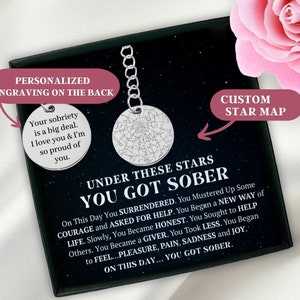 May include: A black box containing a silver keychain with a custom star map. The box features a message that reads "Under these stars you got sober." The message continues with a description of the journey to sobriety. The keychain is personalised with the text "Your sobriety is a big deal. I love you & I'm so proud of you."