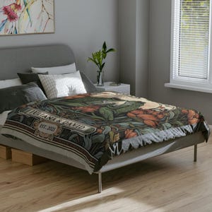 May include: A bed with a floral patterned duvet cover featuring a green frog and the text "Juliana & David Est. 2021".