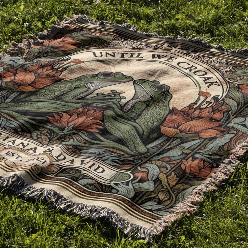 May include: A woven tapestry with a beige background featuring two green frogs, floral designs, and the text "Until We Croak" and "Iana & David Est. 2021".