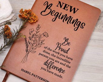 Può includere: Un diario in pelle marrone con il testo "NEW Beginnings" e "Be Proud of the work you have done, the incredible person you are and the difference you have made." Il diario è personalizzato con il nome "ISABEL PATTERSON".