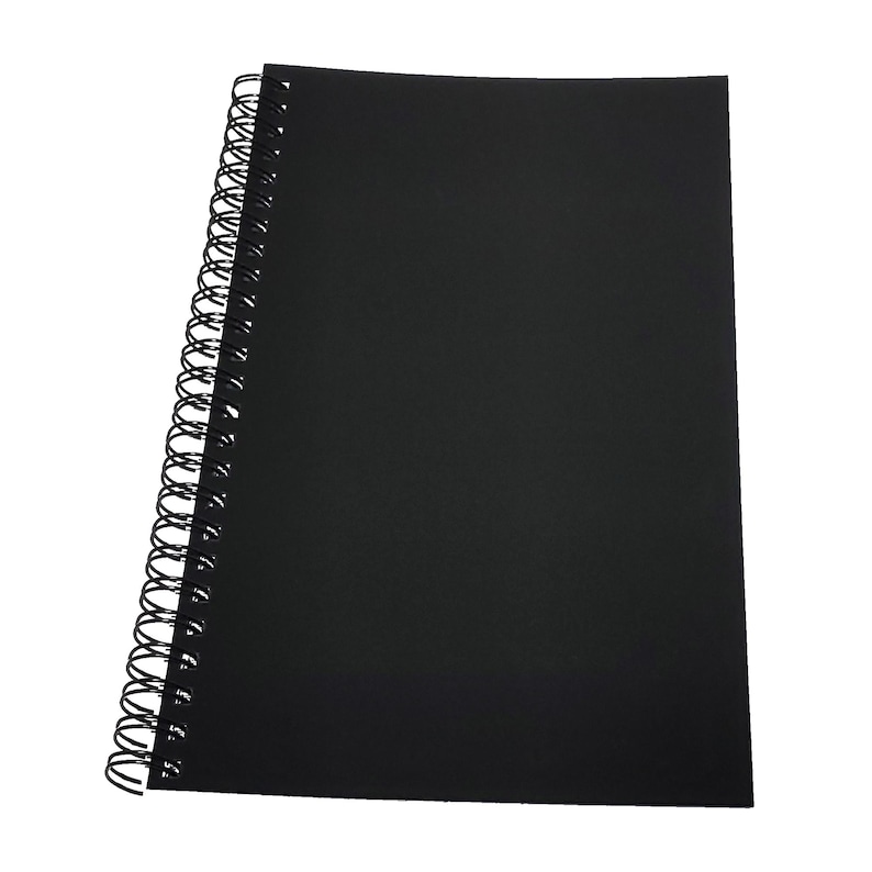 May include: A black spiral bound notebook with a black cover.