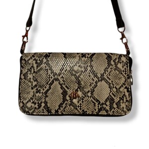 May include: A small, black and beige snakeskin-patterned crossbody bag with a gold bee charm. The bag has a zipper closure and a long adjustable strap.