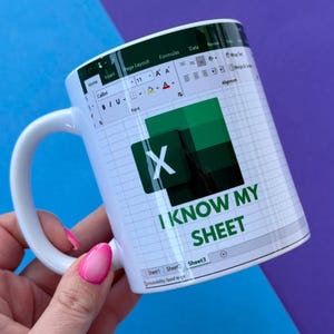 May include: White ceramic mug with an Excel spreadsheet design, the Excel logo, and the text "I KNOW MY SHEET." The mug has a white handle. The background is blue and purple.