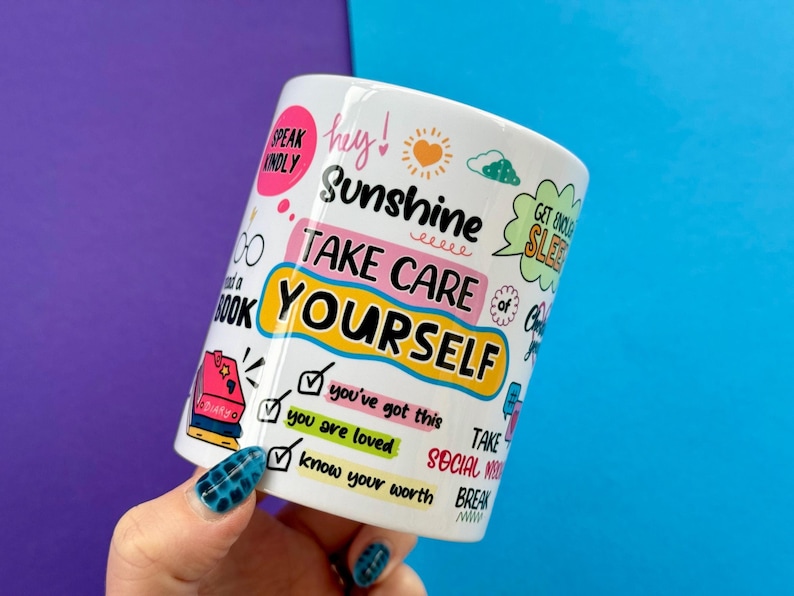 May include: White ceramic mug with colorful text and illustrations. The mug features the words "Sunshine, Take Care of Yourself" and other positive affirmations. Additional text includes "Speak Kindly", "Get Enough Sleep", and "Know Your Worth".