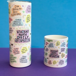 May include: Two white mugs with colorful text and illustrations. The larger mug is a tumbler with a lid. Both mugs feature the text "Student Nurse Daily Affirmations".