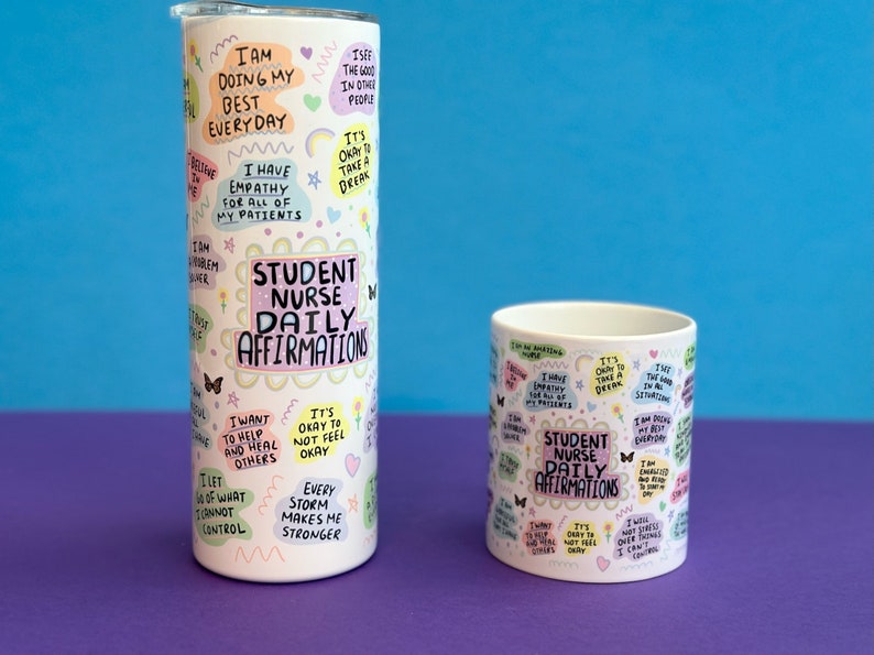 May include: Two white mugs with colorful text and illustrations. The larger mug is a tumbler with a lid. Both mugs feature the text "Student Nurse Daily Affirmations".