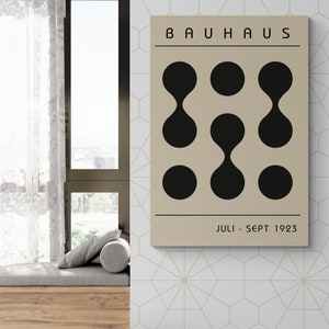May include: A beige poster with black text that reads "BAUHHAUS" and "JULI - SEPT 1923". The poster features a geometric design of nine black circles and ovals.