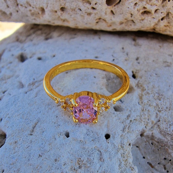 Gold-colored ring set with a pink zircon