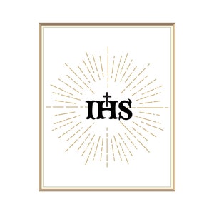 May include: A framed print with a gold frame and a white background. The print features a black stylized "IHS" with a cross above the "H" surrounded by a gold sunburst.