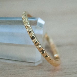 Puede incluir: Un fino anillo de banda de oro con un acabado texturizado y martillado.