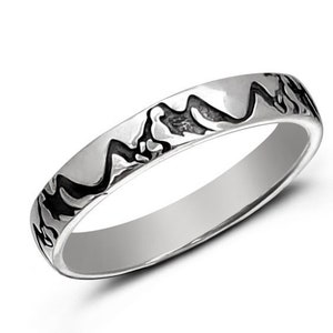 May include: A silver band ring with a mountain range design etched into the band.