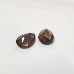 May include: Two brown faceted gemstone drops, each with a teardrop shape.
