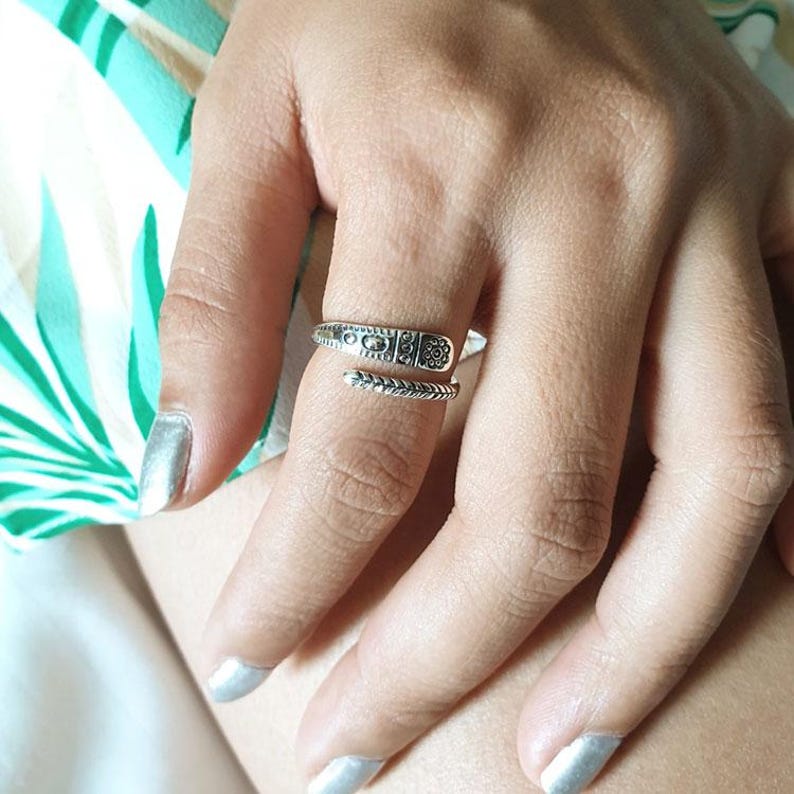 Puede incluir: Un anillo de plata con un dise&ntilde;o texturizado. El anillo est&aacute; envuelto alrededor de un dedo y tiene un extremo puntiagudo.