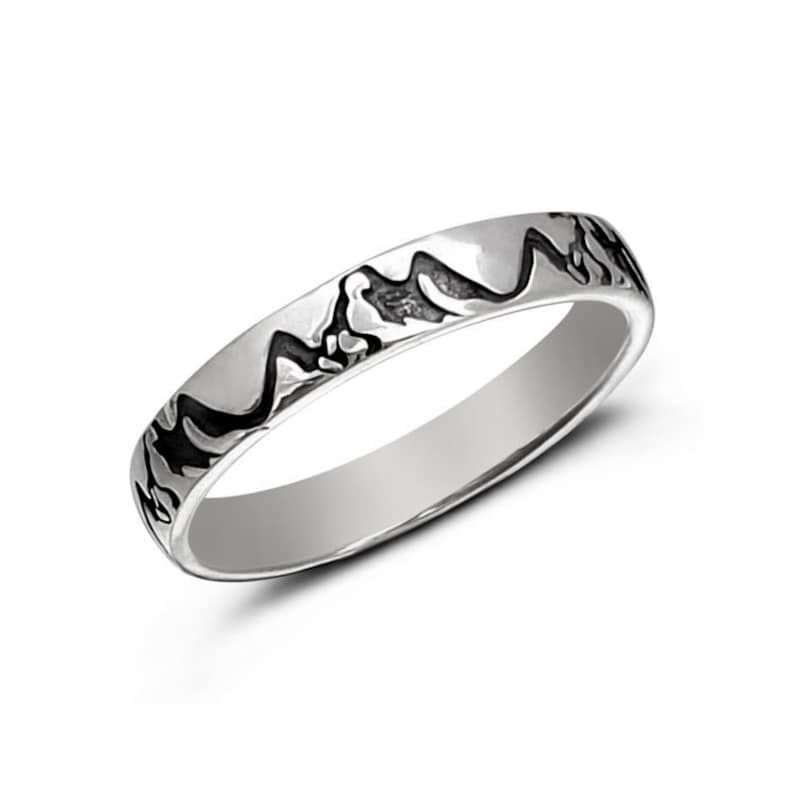 May include: A silver band ring with a mountain range design etched into the band.