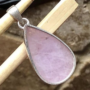 Peut inclure: Un pendentif en argent avec une pierre pr&eacute;cieuse rose en forme de larme.