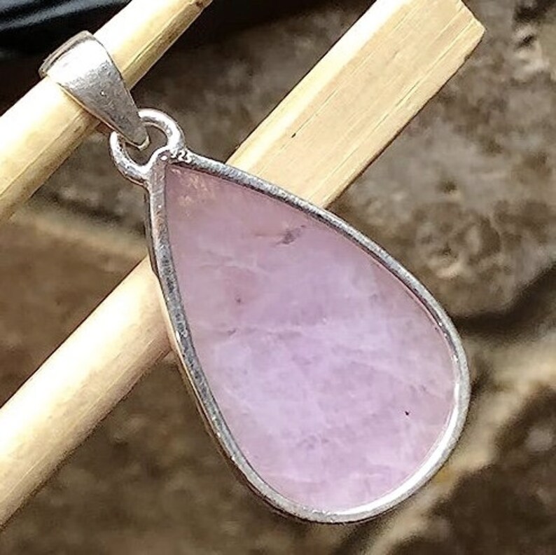 Peut inclure: Un pendentif en argent avec une pierre pr&eacute;cieuse rose en forme de larme.