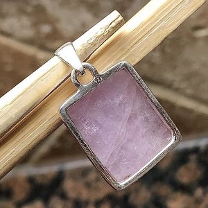 Peut inclure: Un pendentif en argent avec une pierre rose rectangulaire. Le pendentif porte le poin&ccedil;on 925 au dos.