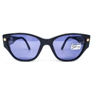 Genny 169s schwarze Cat Eye Sonnenbrille aus Acetat mit dunkelblauen Gläsern und gold glänzenden Pins