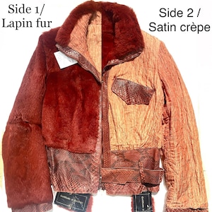 May include: A reversible jacket with one side made of red faux fur and the other side made of a brown satin crepe fabric. The jacket has a zipper closure, a collar, and a belt. The jacket is labelled "Side 1/ Lapin fur" and "Side 2/ Satin crepe".
