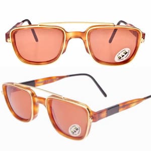 Może przedstawiać: Okulary przeciwsłoneczne w kolorze żółwim z złotymi akcentami i pomarańczowymi szkłami. Okulary przeciwsłoneczne mają funkcję zaczepiania dodatkowych szkieł.