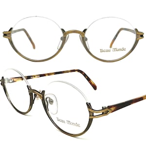 May include: Gold-tone round eyeglasses with a tortoise shell temple. The glasses have a clear lens and the brand name "Beau Monde" is printed on the right lens.