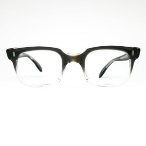 Op de afbeelding: Een bril van zwart en transparant plastic met een rechthoekig montuur.