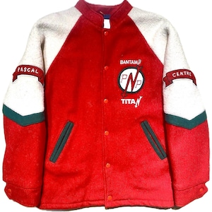 May include: A red and white letterman jacket with green accents. The jacket features the words "PASCAL" and "CENTRE" on the sleeves, and "BANTAMB" and "TITAN" on the chest. The jacket has a button-up front and two front pockets.