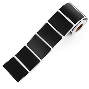 May include: A roll of black label stickers with a white border. The stickers are rectangular and are arranged in a row. The roll is partially unrolled, revealing the adhesive backing.