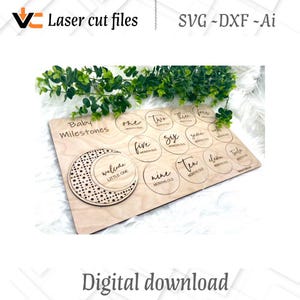 May include: A wooden baby milestone board with laser-cut text and circular cutouts for each month. The board includes the text "Baby Milestones" and "welcome LITTLE ONE". The design is suitable for digital download.