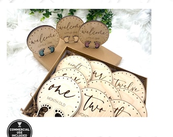 Puede incluir: Un conjunto de 12 círculos de madera cortados con láser con los números del uno al doce y las palabras "month old" y "welcome little one". Los círculos están en una caja con virutas de madera. Los círculos son para las fotos de los hitos mensuales de un bebé.