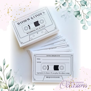 May include: A white cassette tape-themed wedding song request card with black text. The card has a space for the song title, artist, and a place for the guest to write their name. The text on the card reads "MATHEW & CINDY'S WEDDING PLAY LIST SONG REQUEST I promise to dance if you play the above song REQUESTED BY: HAPPY PRINTZ Occasions"