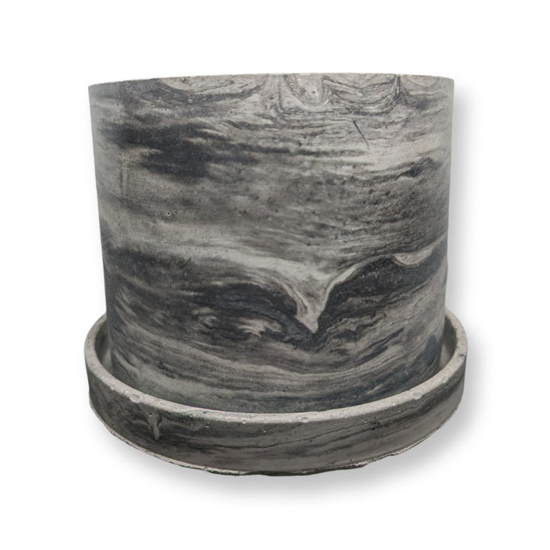 May include: A grey and black marbled ceramic planter with a matching saucer. The planter has a smooth, rounded shape and a subtle swirl pattern.