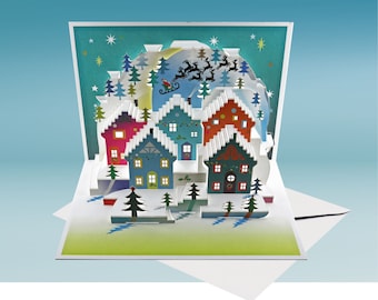 Puede incluir: Una tarjeta de Navidad en 3D con un pueblo nevado con casas coloridas, un árbol verde y Papá Noel volando en un trineo con renos. La tarjeta tiene un cielo azul con estrellas blancas.