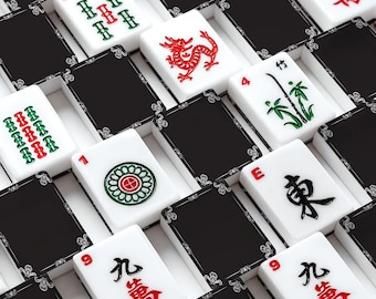 May include: A collection of mahjong tiles arranged in a grid pattern. The tiles feature white faces with red, green, and black engraved symbols, characters, and numbers, contrasted against solid black backs with decorative white filigree corner details.