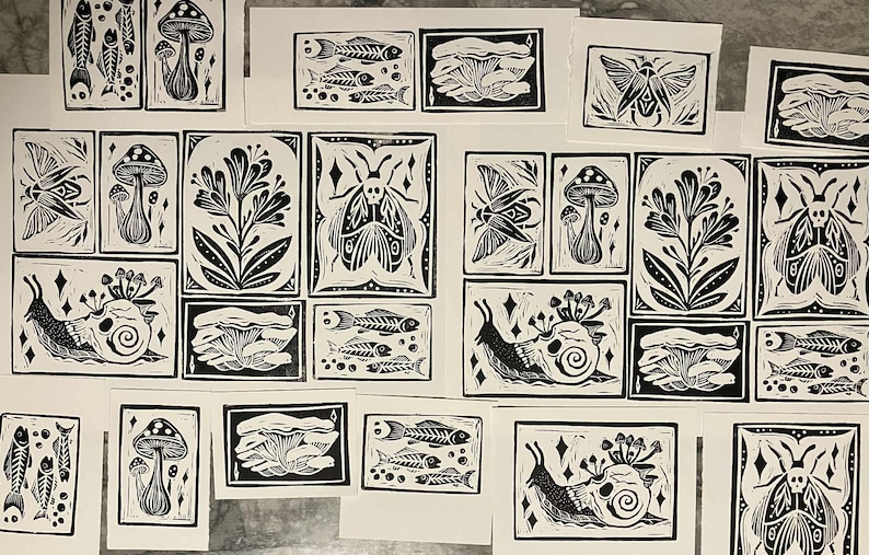 Peut inclure: Ensemble de linogravures en noir et blanc repr&eacute;sentant des motifs inspir&eacute;s de la nature. Les impressions pr&eacute;sentent des champignons, des squelettes de poissons, des insectes, des plantes et des escargots. Chaque tirage est rectangulaire avec un bord noir.