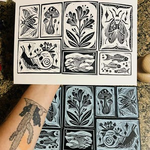 Peut inclure: Estampes en linogravure en noir et blanc repr&eacute;sentant des motifs botaniques et d'insectes. Les estampes comprennent des images de champignons, de fleurs, d'un papillon de nuit, d'un escargot avec un cr&acirc;ne et de squelettes de poissons. Les estampes sont affich&eacute;es sur fond blanc.