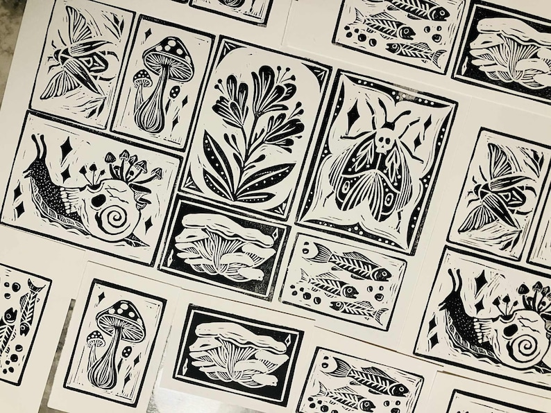 Peut inclure: Estampes en linogravure en noir et blanc repr&eacute;sentant divers motifs inspir&eacute;s de la nature. Les estampes comprennent des images de champignons, d'escargots, de papillons de nuit, de squelettes de poissons et d'&eacute;l&eacute;ments floraux.