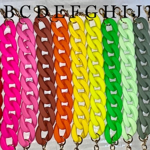 Puede incluir: Diez eslabones de cadena gruesos y coloridos en varios colores, incluyendo rojo, rosa, marrón, naranja, amarillo, verde, verde claro, gris y blanco. Las cadenas están hechas de un material similar al caucho y tienen cierres de color dorado.