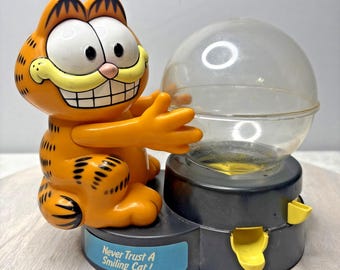Dispensador de caramelos Gumball de Garfield: "¡Nunca confíes en un gato sonriente!" (1990 Dakin Appl