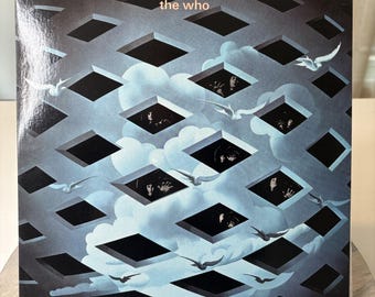 Può includere: Copertina dell'album "Tommy" dei The Who. L'artwork presenta un design geometrico di forme a diamante nere su uno sfondo di cielo blu con nuvole. Uccelli bianchi volano attraverso la scena e il nome della band è in alto.