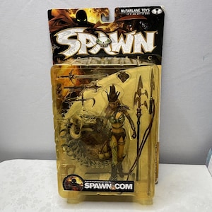 Peut inclure: Figurine Spawn de McFarlane Toys dans son emballage d'origine. La figurine représente une guerrière avec une lance et un monstre. L'emballage porte le logo Spawn et le texte "Spawn.com".