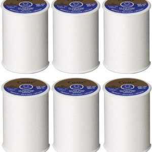 May include: Six spools of white Coats thread, each with a blue label that reads "Coats All Purpose Fil Tout Usage Hilo Para Uso General 400 yds 365 m Greer, SC 29650 Mexico/Mexique/Mexico".