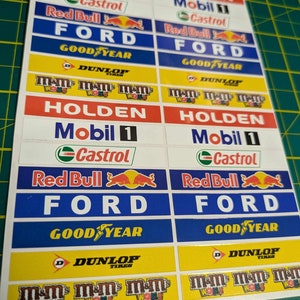 Könnte beinhalten: Ein Satz von 10 Auto-Renn-Sponsor-Aufklebern mit den Logos von Holden, Mobil 1, Castrol, Red Bull, Ford, Goodyear und M&M's.