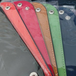 Pu&ograve; includere: Un set di nove braccialetti in pelle di vari colori, tra cui grigio, arancione, rosso, marrone, verde, blu navy e viola. Ogni braccialetto ha una chiusura a scatto argentata.