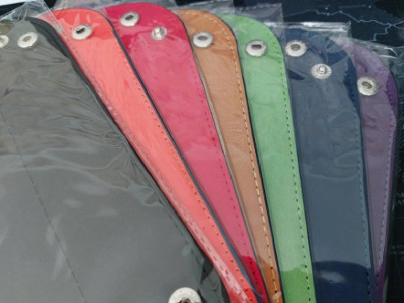 Pu&ograve; includere: Un set di nove braccialetti in pelle di vari colori, tra cui grigio, arancione, rosso, marrone, verde, blu navy e viola. Ogni braccialetto ha una chiusura a scatto argentata.
