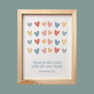 May include: A framed print with a white background and a colorful heart pattern. The print includes the text "Trust in the Lord with all your Heart" and "Proverbs 3:5".