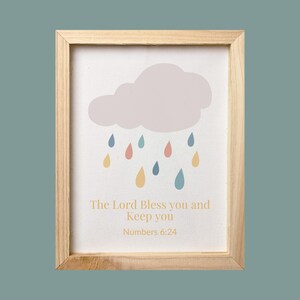 May include: A framed print with a light purple cloud and colorful raindrops. The text reads "The Lord Bless you and Keep you Numbers 6:24".