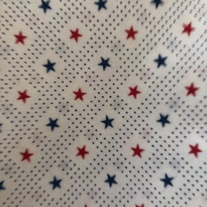 May include: White fabric with a repeating pattern of red and blue stars on a white background with small blue dots.